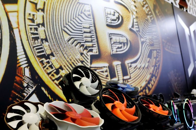 Cryptocurrency mining computer fans are seen in front of bitcoin logo during the annual Computex computer exhibition in Taipei, Taiwan June 5, 2018. REUTERS/Tyrone Siu