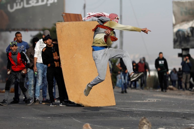 A Palestinian demonstrator hurls stones towards Israeli troops during clashes at a protest against U.S. President Donald Trump's decision to recognise Jerusalem as the capital of Israel, near the West Bank city of Nablus, December 29, 2017. REUTERS/Mohamad Torokman