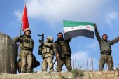 1月28日，土耳其士兵和叙利亚自由军战士在叙利亚阿夫林北部地区的Barsaya山上挥舞国旗。[Reuters/Khalil Ashawi]