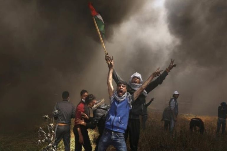 当两组愤怒的巴勒斯坦青年相遇并高呼突破以色列隔离墙时，摄影师捕捉到了这个镜头[路透社]