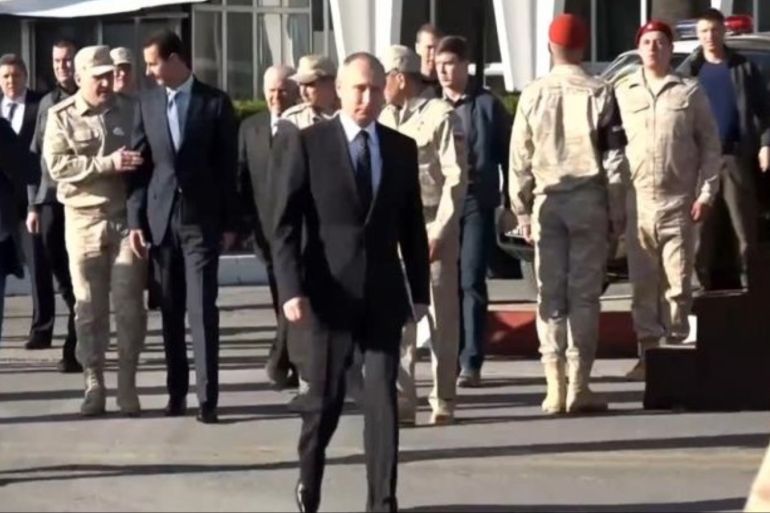 بوتين خلال زيارته قاعدة حميميم بسوريا أواخر العام الماضي (الجزيرة)