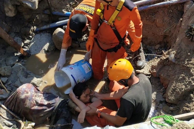 Search and rescue workers help rescue a person trapped in rubble following an earthquake and tsunami in Palu, Central Sulawesi, Indonesia September 30, 2018 in this photo taken by Antara Foto. Antara Foto/Darwin Fatir/via REUTERS. ATTENTION EDITORS - THIS IMAGE WAS PROVIDED BY A THIRD PARTY. MANDATORY CREDIT. INDONESIA OUT.