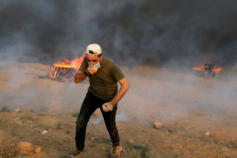 A demonstrator runs from tear gas during a protest where Palestinians demand the right to return to their homeland, at the border fence between Israel and Gaza, east of Gaza City August 31, 2018. REUTERS/Mohammed Salem
