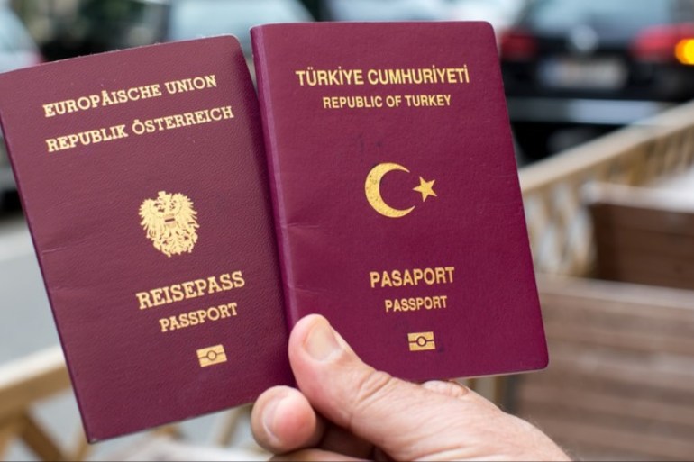 person holds a Turkish (R) and an Austrian (L) passport