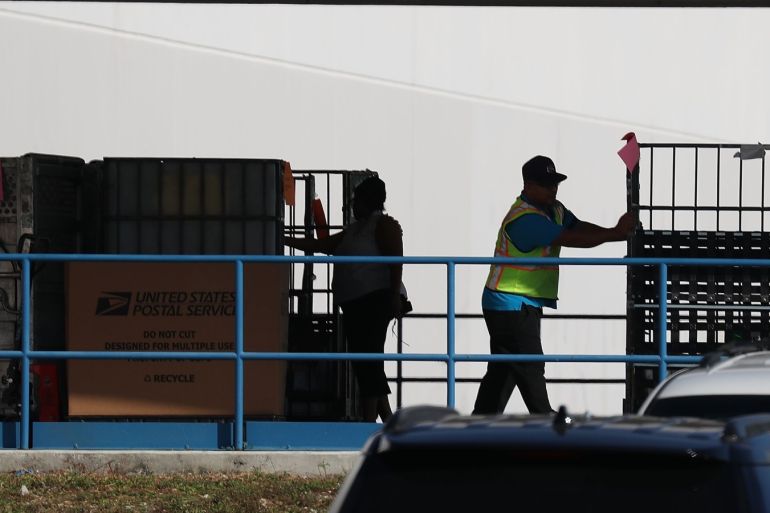 OPA LOCKA, FL - OCTOBER 26: U.S. Postal workers are seen at the U.S. Postal Service mail facility where federal law enforcement personel are investigating pipe bombs that passed through the facility on October 26, 2018 in Opa Locka, Florida. The pipe bombs were mailed to some critics of President Donald Trump. Joe Raedle/Getty Images/AFP== FOR NEWSPAPERS, INTERNET, TELCOS & TELEVISION USE ONLY ==