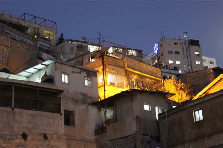 ‎⁨3-صورة عامة لحي بطن الهوى يظهر بها نجمة إسرائيل على بؤرة استيطانية مكونة من بناية استولى عليها المستوطنون عام 20014(الجزيرة نت)⁩
