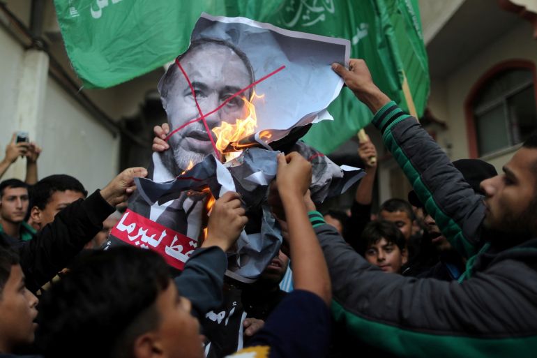 Palestinians burn a poster depicting Israel's Defence Minister Avigdor Lieberman as they celebrate after Lieberman announced his resignation, in Gaza City November 14, 2018. REUTERS/Suhaib Salem TPX IMAGES OF THE DAY