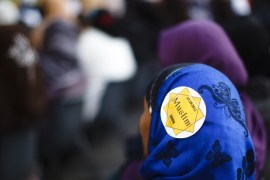 A Muslim woman wearing a hijab with a sticker reading 'Muslim, Bern' listens to speakers during during a protest against islamophobia and racism organized by the Islamic Central Council of Switzerland (ICCS), in Bern October 29, 2011. REUTERS/Michael Buholzer (SWITZERLAND - Tags: POLITICS RELIGION CIVIL UNREST)