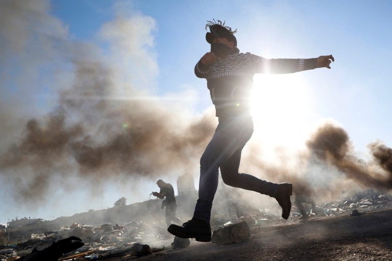 A Palestinian hurls stones during clashes with Israeli troops near the Jewish settlement of Beit El, near Ramallah, in the Israeli-occupied West Bank December 13, 2018. REUTERS/Mohamad Torokman