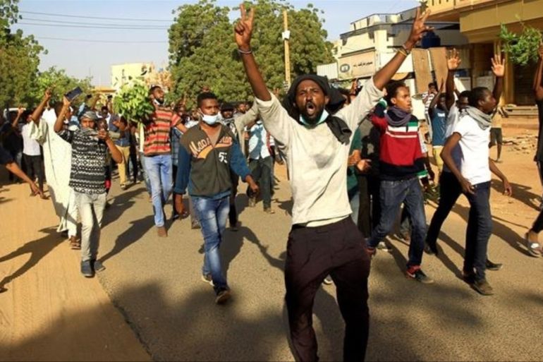 Demonstrators chant slogans as they march along the street during anti-government protests in Khartoum [Mohamed Nureldin Abdallah/Reuters]