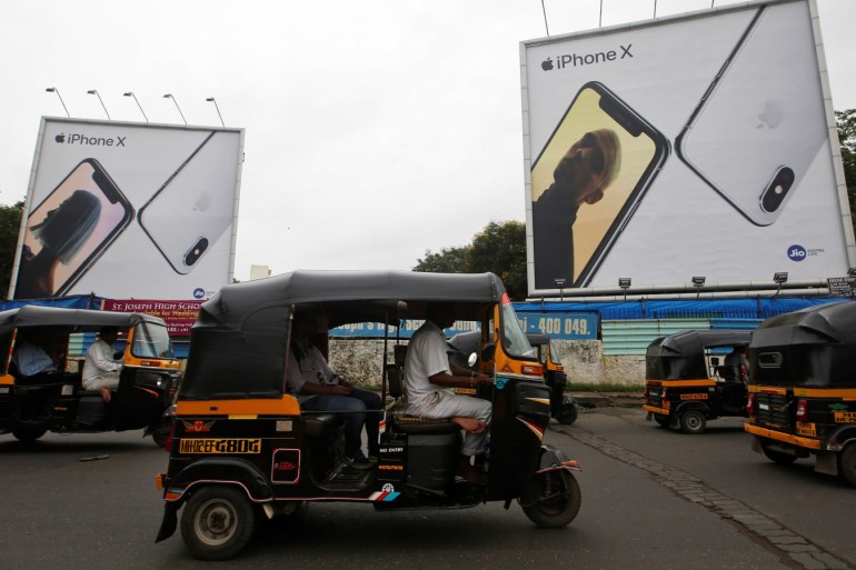 Auto-rickshaws drive past the hoardings of Apple iPhone X mobile phones in Mumbai, India July 27, 2018. Picture taken July 27, 2018. REUTERS/Francis Mascarenhas