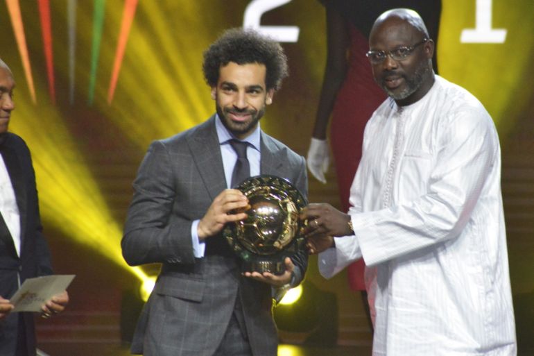epa07270316 Mohamed Salah from Egypt (C) receives the Player of the Year award from Liberian president George Weah (R) and CAF president Ahmad Ahmad (L) during the Confederation of African Football (CAF) awards at the Abdou Diouf International Conference Center in Dakar, Senegal, 08 January 2019. EPA-EFE/STR