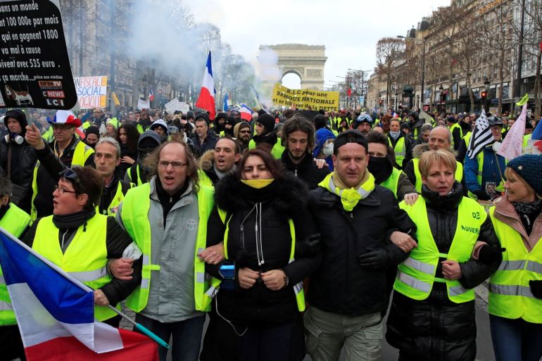 Protesters wearing yellow vests take part in a demonstration by the