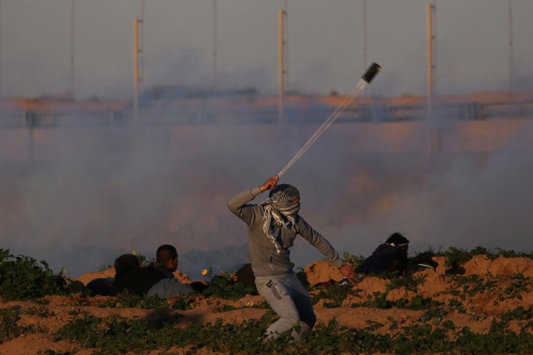 A Palestinian demonstrator hurls stones at Israeli troops during a protest at the Israel-Gaza border fence, in the southern Gaza Strip January 18, 2019. REUTERS/Ibraheem Abu Mustafa