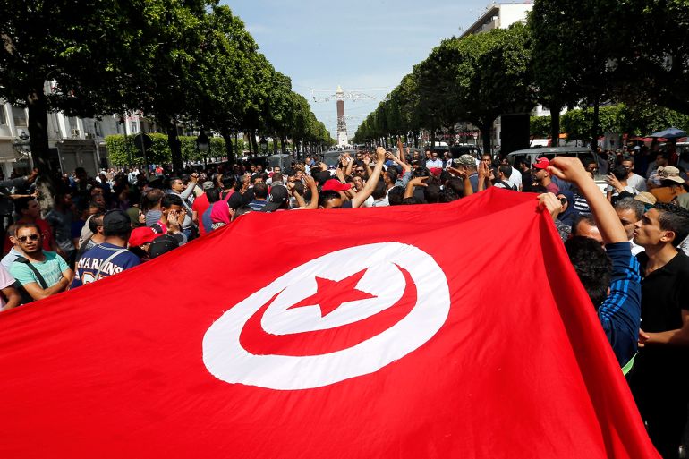 epa05982076 Tunisian protesters hold Tunisia flag and shout slogans during a demonstration to support unemployed Tunisians after a person was killed on clashes between security forces and protesters, in Tataouine, South of Tunis, Tunisia, 22 May 2017. Agitation broke out in recent days at the oil and gas pumping station El Kamour in the Tataouine region south of Tunis, protesters blocking truck access to the site to demand priority in jobs in the sector. EPA/MOHAMED MESSARA