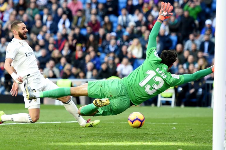 MADRID, SPAIN - FEBRUARY 17: Yassine Bounou of Girona dives to save the ball from Karim Benzema of Real Madrid during the La Liga match between Real Madrid CF and Girona FC at Estadio Santiago Bernabeu on February 17, 2019 in Madrid, Spain. (Photo by Denis Doyle/Getty Images)