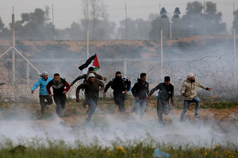 Palestinian demonstrators run away from Israeli fire and tear gas during a protest at the Israel-Gaza border fence, in the southern Gaza Strip February 15, 2019. REUTERS/Ibraheem Abu Mustafa TPX IMAGES OF THE DAY