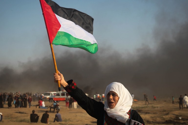 'Great March of Return' protests continue in Gaza- - GAZA CITY, GAZA - SEPTEMBER 28: A Palestinian womanw aves a flag of Palestine during a