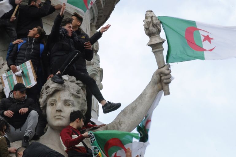 Protestors hold Algerian flags as they attend a demonstration against President Abdelaziz Bouteflika on the Place de la Republique, in Paris, France, March 10, 2019. REUTERS/Philippe Wojazer