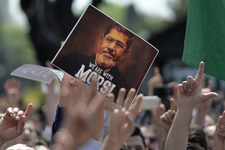 A picture of Mohamed Morsi is held aloft and the four fingered salute associated with the killing of Muslim Brotherhood supporters during a protest against an Egyptian court's decision to seek the death sentence for deposed Egyptian President, Mohamed Morsi, Istanbul, Turkey, 24 May 2015. Turkey has held a critical position toward Egypt since Mohamed Morsi was deposed by the Egyptian military July 2013, and following a court decision to seek the death sentence for Morsi on charges of a 2011 prison break 16 May, Erdogan heavily criticised the incumbent regime of Abdel Fattah al-Sisi and the West for its lack of response to the sentence