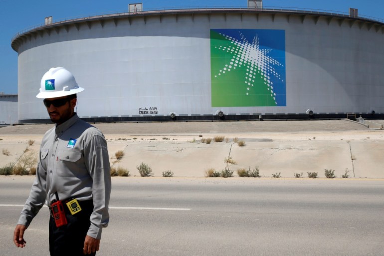 An Aramco employee walks near an oil tank at Saudi Aramco's Ras Tanura oil refinery and oil terminal in Saudi Arabia May 21, 2018. Picture taken May 21, 2018. REUTERS/Ahmed Jadallah