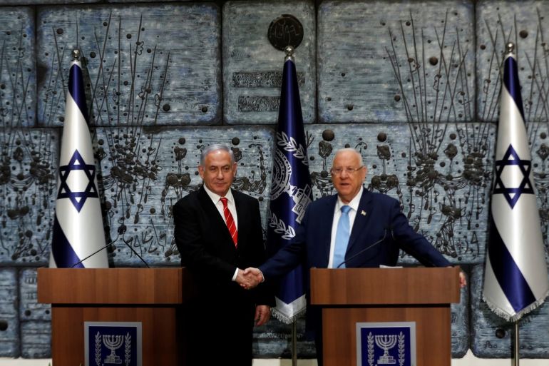 Israeli President Reuven Rivlin and Prime Minister Benjamin Netanyahu shake hands during a nomination ceremony at the President's residency in Jerusalem September 25, 2019. REUTERS/Ronen Zvulun