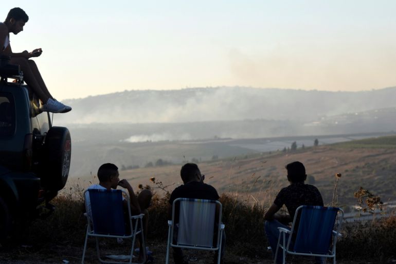 Israelis sit and watch smoke on the Lebanese side of the Israel-Lebanon border, as seen from its Israeli side September 1, 2019. REUTERS/Rami Shlush ISRAEL OUT. NO COMMERCIAL OR EDITORIAL SALES IN ISRAEL