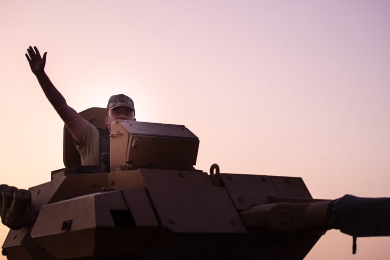 AKCAKALE, TURKEY - OCTOBER 09: A Turkish soldier waves on the top of an armored vehicle as the troops prepare to cross the border into Syria on October 09, 2019 in Akcakale, Turkey. The military action is part of a campaign to extend Turkish control of more of northern Syria, a large swath of which is currently held by Syrian Kurds, whom Turkey regards as a threat. U.S. President Donald Trump granted tacit American approval to this campaign, withdrawing his country's troops from several Syrian outposts near the Turkish border. (Photo by Burak Kara/Getty Images)