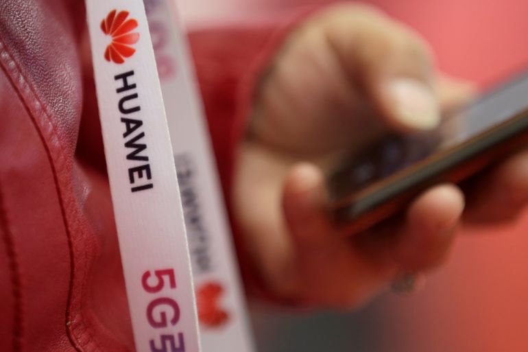 An attendee wears a badge strip with the logo of Huawei and a sign for 5G at the World 5G Exhibition in Beijing, China November 22, 2019. REUTERS/Jason Lee
