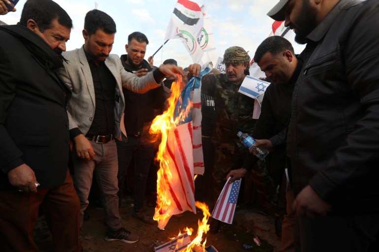 Iraqi people burn an Israeli and a U.S. flag in a protest after an airstrike at the headquarters of Kataib Hezbollah militia group in Qaim, in Kirkuk, Iraq, December 30, 2019. REUTERS/Ako Rasheed