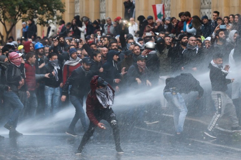 Demonstrators are hit by water canon during a protest against a ruling elite accused of steering Lebanon towards economic crisis in Beirut, Lebanon January 18, 2020. REUTERS/Mohamed Azakir