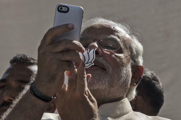 AHMEDABAD, INDIA - APRIL 30: BJP leader Narendra Modi takes a picture of himslef, his inked finger and the party insignia with his mobile phone after voting at a polling station on April 30, 2014 in Ahmedabad, India. India is in the midst of a nine-phase election that started on April 7 and ends May 12. (Photo by Kevin Frayer/Getty Images)