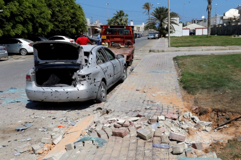 Workers remove a damaged civilian vehicle, after a missile hit the terminal's park of Mitiga airport in Tripoli, Libya August 24, 2019. REUTERS/Ismail Zitouny