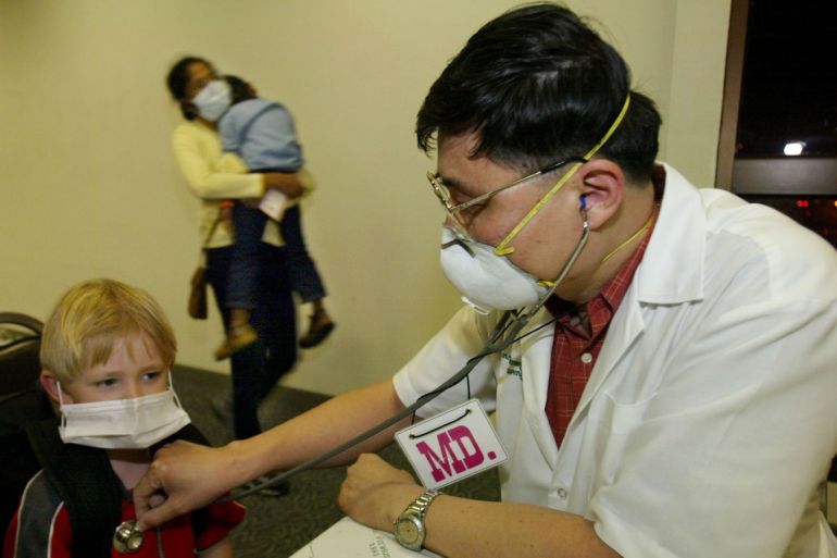 BANGKOK, THAILAND - APRIL 22: A Thai doctor performs a brief health check on a child after he arrived in Bangkok from Hong Kong at the Bangkok International Airport April 22, 2003 in Bangkok, Thailand. Hong Kong and China reported 10 new deaths from SARS today. Scientists said that the virus thought to cause SARS is constantly changing its form, which will make developing a vaccine difficult and suspect that the cause to be a new strain of the coronavirus, which may have