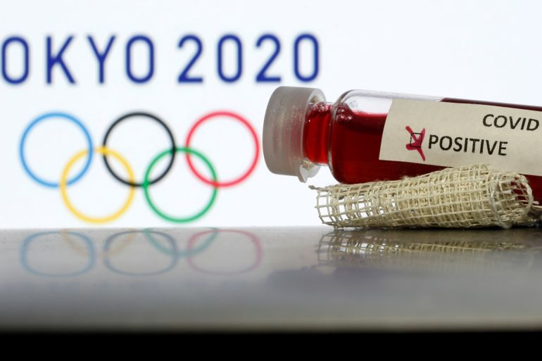 Fake blood in seen in test tubes labelled with coronavirus disease (COVID-19) in front of a displayed Tokyo 2020 Olympics logo in this illustration taken March 19, 2020. REUTERS/Dado Ruvic/Illustration