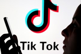 A person holds a smartphone as Tik Tok logo is displayed behind in this picture illustration taken November 7, 2019. Picture taken November 7, 2019. REUTERS/Dado Ruvic/Illustration