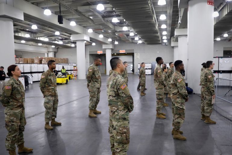 U.S. Army personnel stand apart while looking on as New York Governor Andrew Cuomo speaks while visiting the Jacob K. Javits Convention Center which will be partially converted into a hospital for patients affected by the coronavirus disease (COVID-19) in Manhattan in New York City, New York, U.S., March 23, 2020. REUTERS/Mike Segar TPX IMAGES OF THE DAY