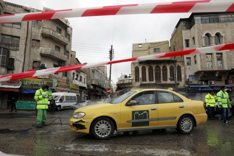 Greater Amman Municipality employees sanitize cars at street amid concerns over the coronavirus disease (COVID-19) spread, outside al Husseini mosque in downtown Amman, Jordan, March 20, 2020. REUTERS/Muhammad Hamed