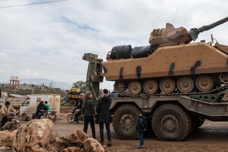 Turkish Military's armoured vehicles that crossed to Syria drive pass in a road in village of Aaqrabate on February 22, 2020 in Idlib