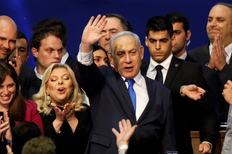 Israeli Prime Minister Benjamin Netanyahu stands next to his wife Sara as he waves to supporters following the announcement of exit polls in Israel's election at his Likud party headquarters in Tel Aviv, Israel March 3, 2020. REUTERS/Amir Cohen