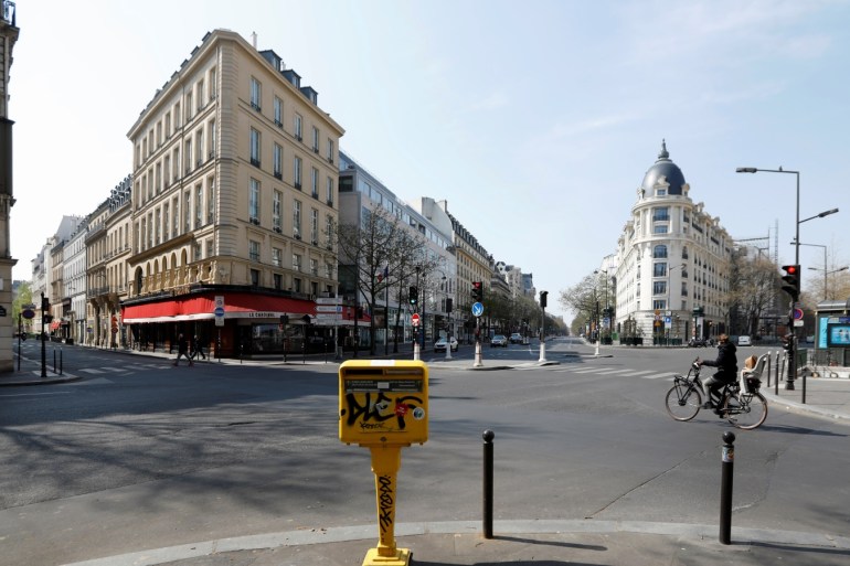 A cyclist rides on the deserted Grands Boulevards in Paris as a lockdown is imposed to slow the rate of the coronavirus disease (COVID-19) in France, March 27, 2020. REUTERS/Charles Platiau