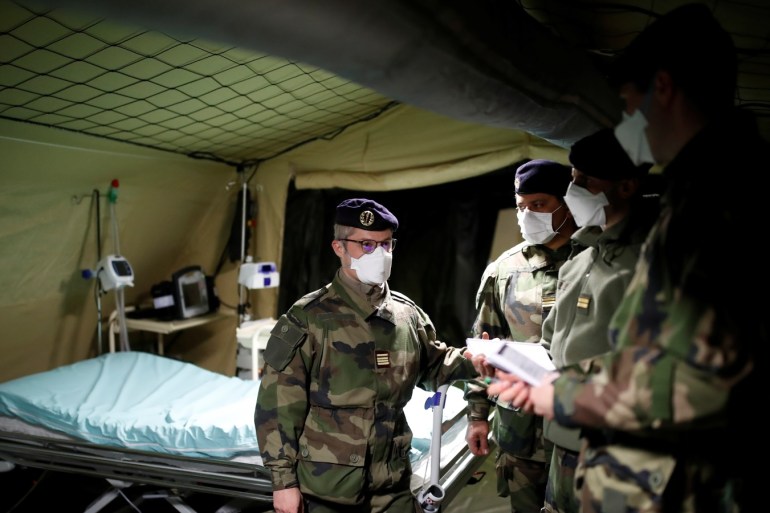 French soldiers, wearing protective face masks, install tents at a miitary field hospital near Mulhouse hospital as France faces an aggressive progression of the coronavirus disease (COVID-19), March 23, 2020. REUTERS/Christian Hartmann