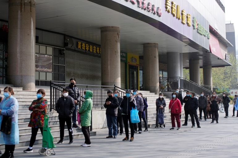 People wearing face masks line up to enter a supermarket in Wuhan, Hubei province, the epicentre of China's coronavirus disease (COVID-19) outbreak, April 1, 2020. REUTERS/Aly Song