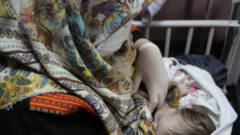 An Afghan mother feeds a newborn baby