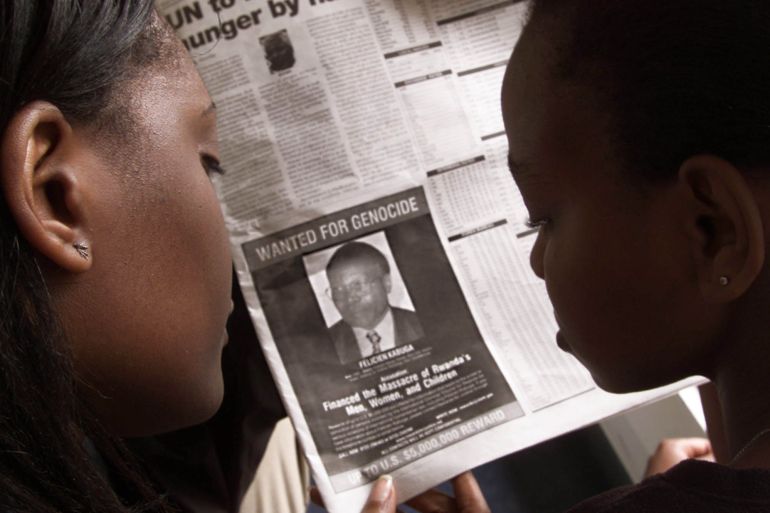 READERS LOOK AT A PICTURE OF A RWANDAN WANTED FOR THE ALLEGED MASTERMIND OF RWANDA'S 1994 GENOCIDE.