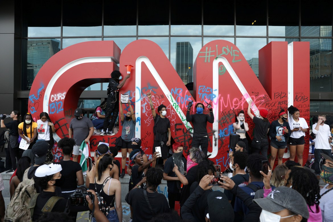 Protesters stand in front of a vandalized CNN logo in front of the CNN Center during a protest against the death in Minneapolis police custody of African-American man George Floyd, in Atlanta