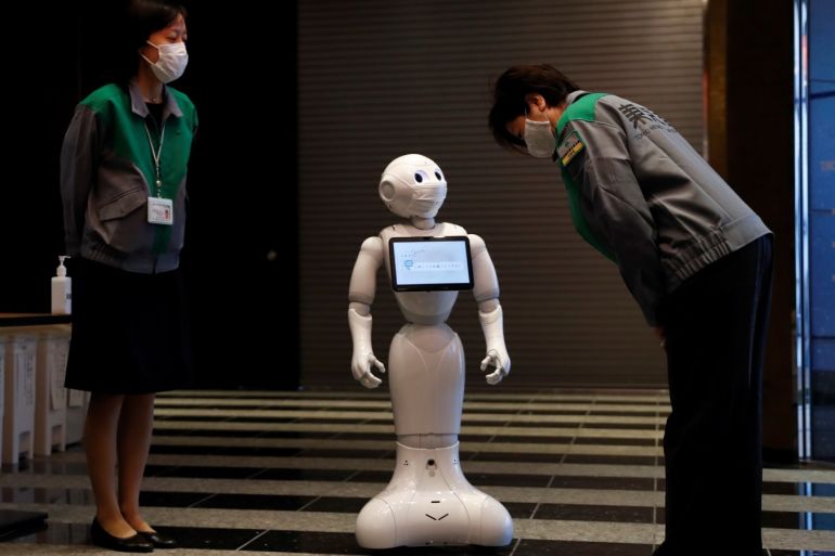 Tokyo Governor Yuriko Koike inspects a Pepper humanoid robot, manufactured by SoftBank Group Corp. during a press preview of a hotel of APA Group that has been designated to accommodate asymptomatic people and those with light symptoms of the coronavirus disease (COVID-19) to free up hospital beds and alleviate work by nurses and staff members, in Tokyo, Japan May 1, 2020. REUTERS/Issei Kato