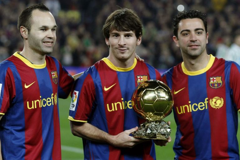 Barcelona's Lionel Messi poses with his Ballon d'Or trophy, the World Player of the Year award, next to his teammates Andres Iniesta (L) and Xavi Hernandez before their Spanish King's Cup soccer match against Real Betis at Nou Camp stadium in Barcelona January 12, 2011. REUTERS/Albert Gea (SPAIN - Tags: SPORT SOCCER)
