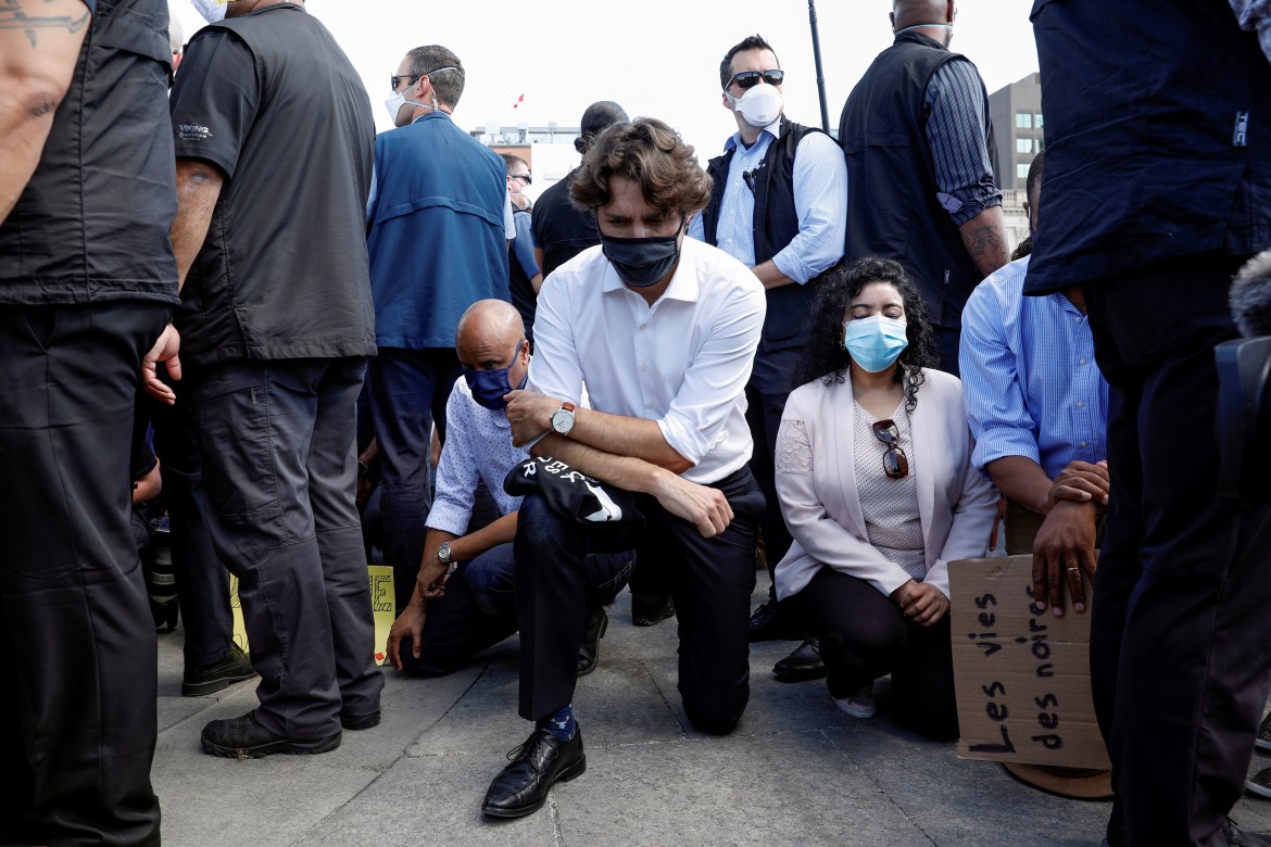 Canada's Prime Minister Justin Trudeau wears a mask as he takes a knee during a rally against the death in Minneapolis police custody of George Floyd, on Parliament Hill, in Ottawa