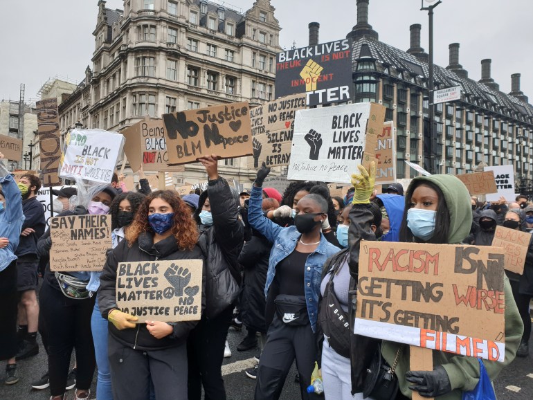 Demonstrators hold signs during a Black Lives Matter protest in Parliament Square, following the death of George Floyd who died in police custody in Minneapolis, in London